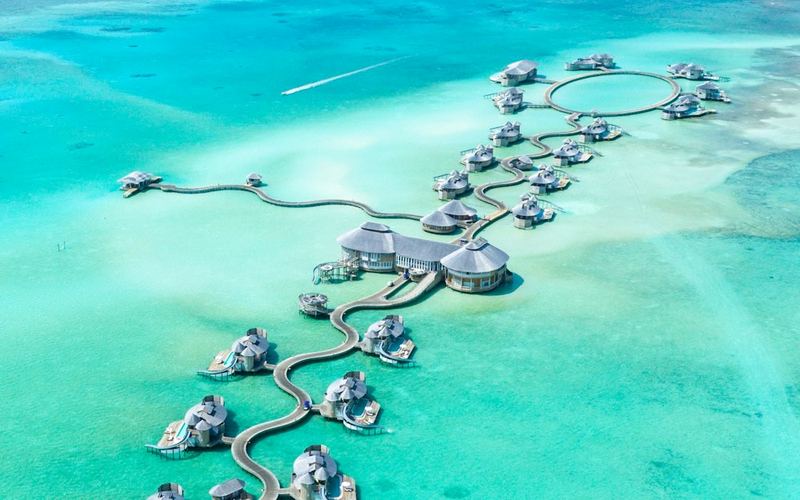 Bangalôs sobre a água em mar azul-turquesa nas Maldivas
